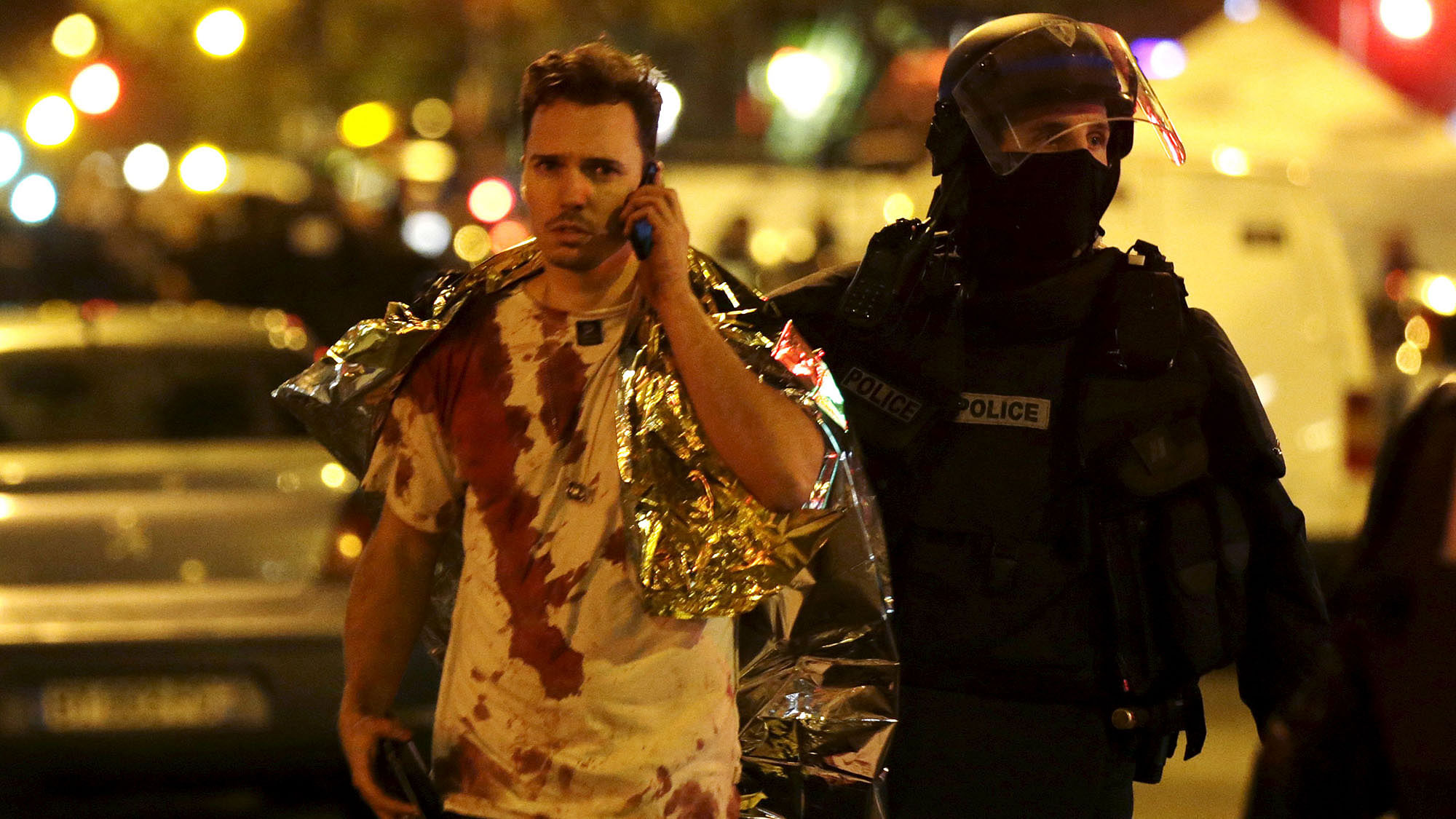 A French policeman assists a blood-covered victim near the Bataclan concert hall following attacks in Paris. (Photo: Reuters)