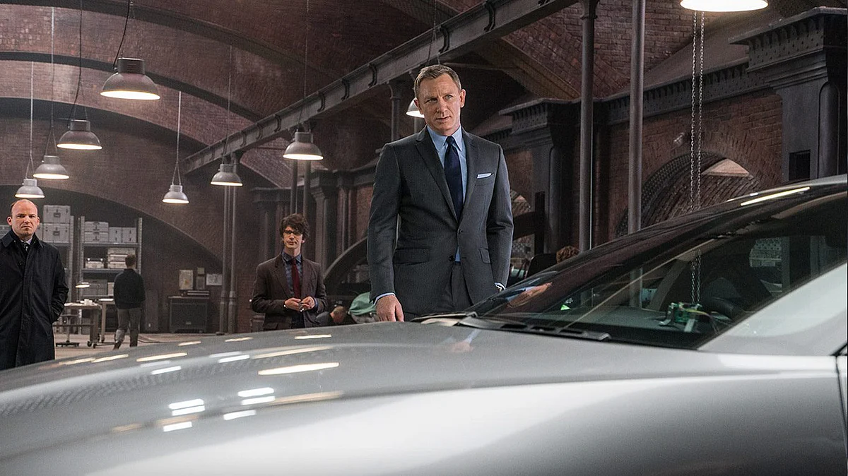 James Bond (Daniel Craig), Q (Ben Whishaw) and Tanner (Rory Kinnear) with the Aston Martin DB10 in <i>Spectre</i>. (Photo Courtesy: <a href="https://www.facebook.com/SpectreMovie/photos/pb.409815059172257.-2207520000.1447991281./482603261893436/?type=3&theater">Spectre’s Facebook page</a>)