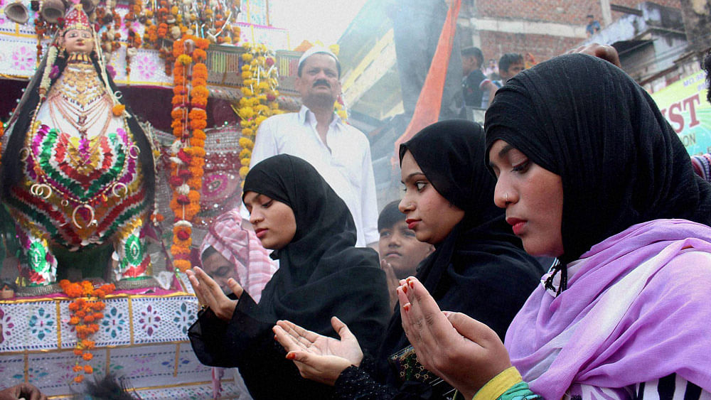Muslim women  offer prayers in front of a tazia during a Muharram procession in Bhopal. (Photo: PTI)
