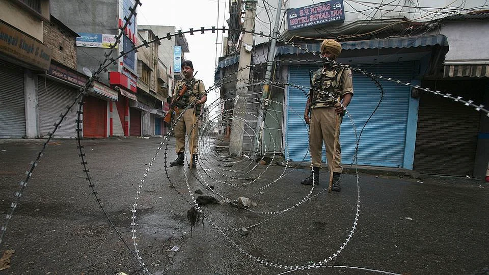 Policemen stand guard on a street in J&K. (Photo: Reuters)