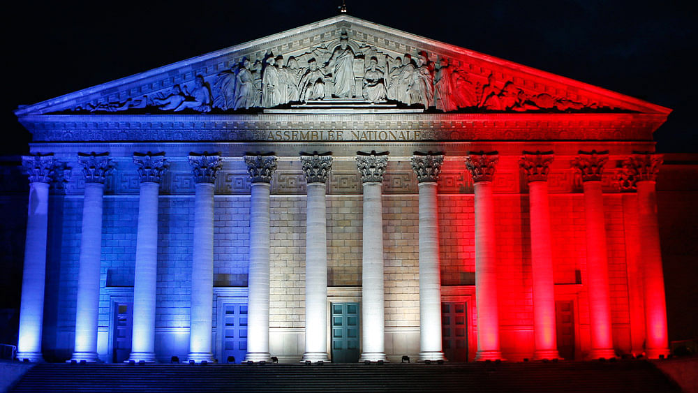The French Assemblee Nationale, which houses the bicameral Parliament, is lit in the national flag colours, in Paris on November 22, 2015, one week after the Paris attacks. (Photo: AP)