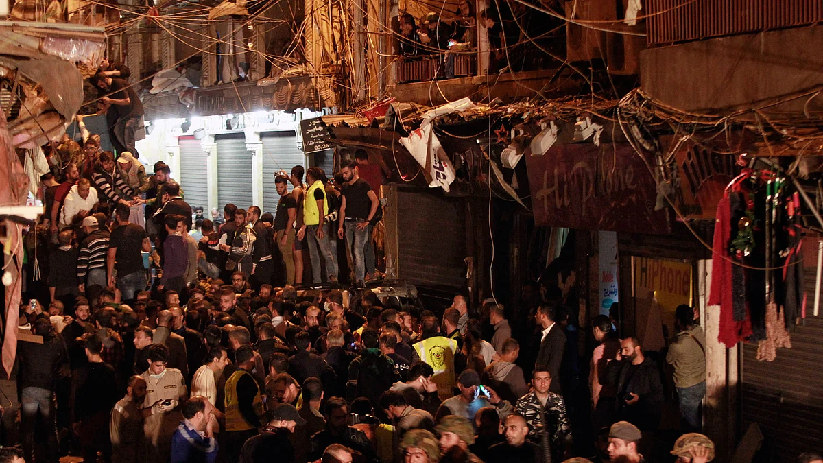 Lebanese army and civilians gather near the site of a twin suicide attack in Burj al-Barajneh, southern Beirut in Lebanon. (Photo: AP)
