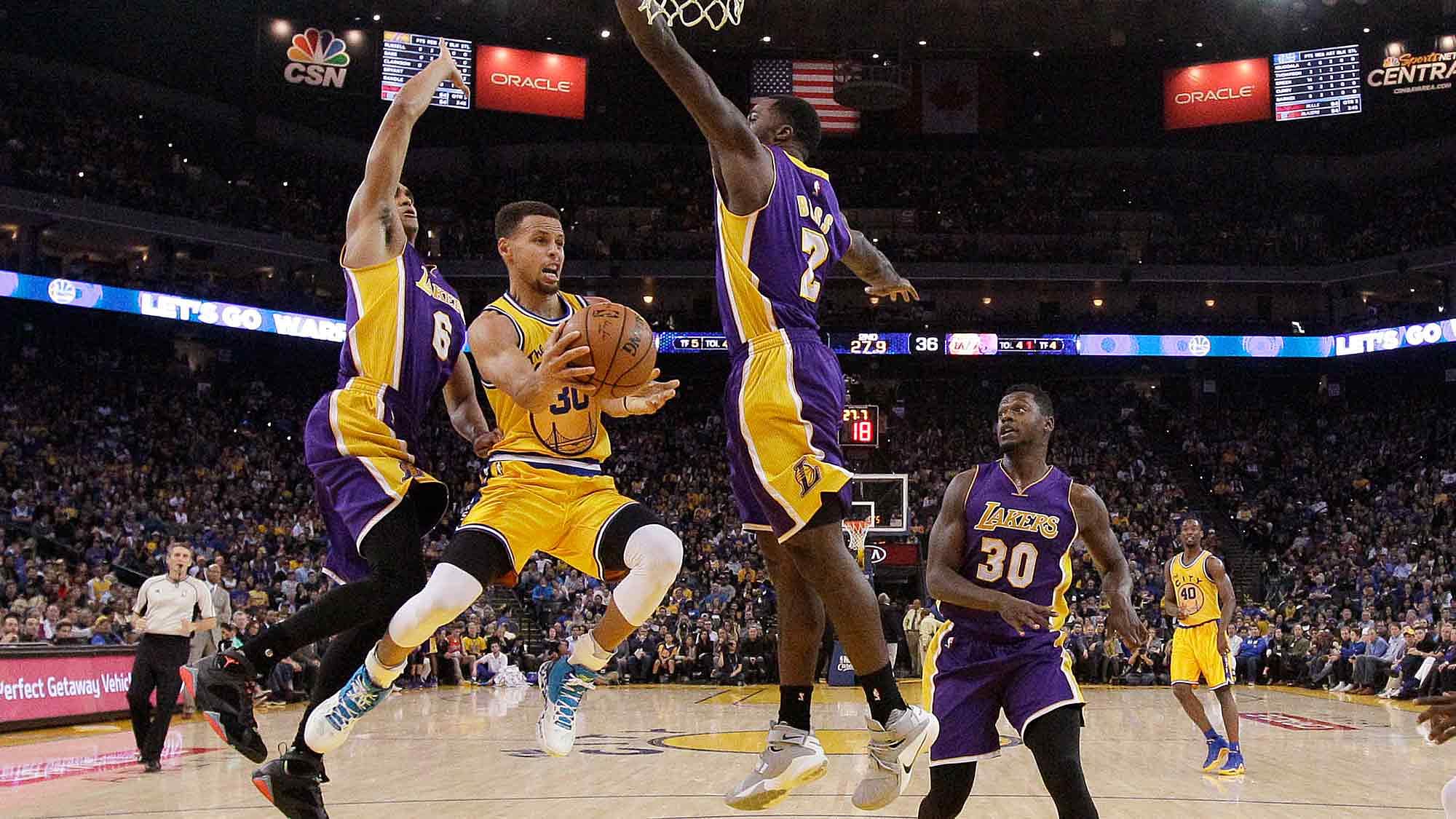 <a></a>Golden State Warriors guard Stephen Curry, center, looks to pass as Los Angeles Lakers guard Jordan Clarkson (6), forward Brandon Bass (2) and forward Julius Randle (30) defend during the first half of the game. (Photo: AP)