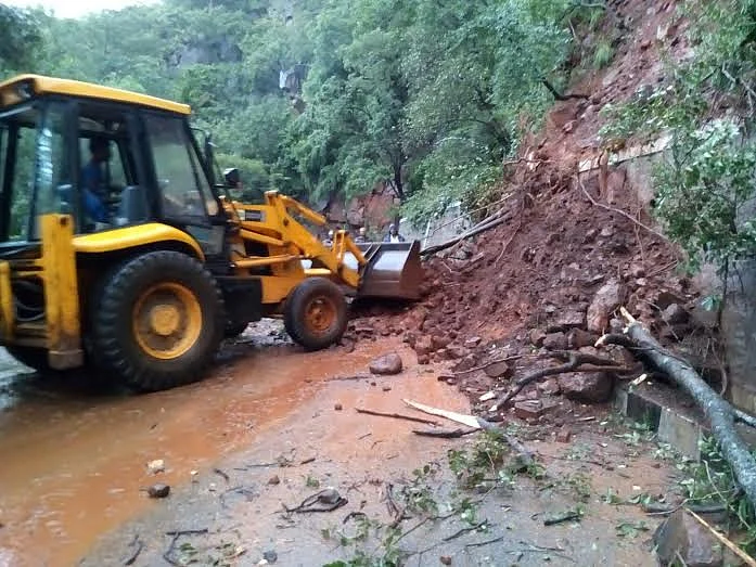 Authorities clear the debris fallen on the ghat road. (Photo Courtesy: The News Minute)