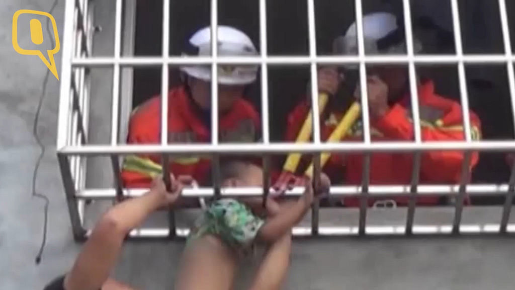 Firefighters trying to rescue the toddler whose head got stuck in the window railing. (Photo: AP screengrab)