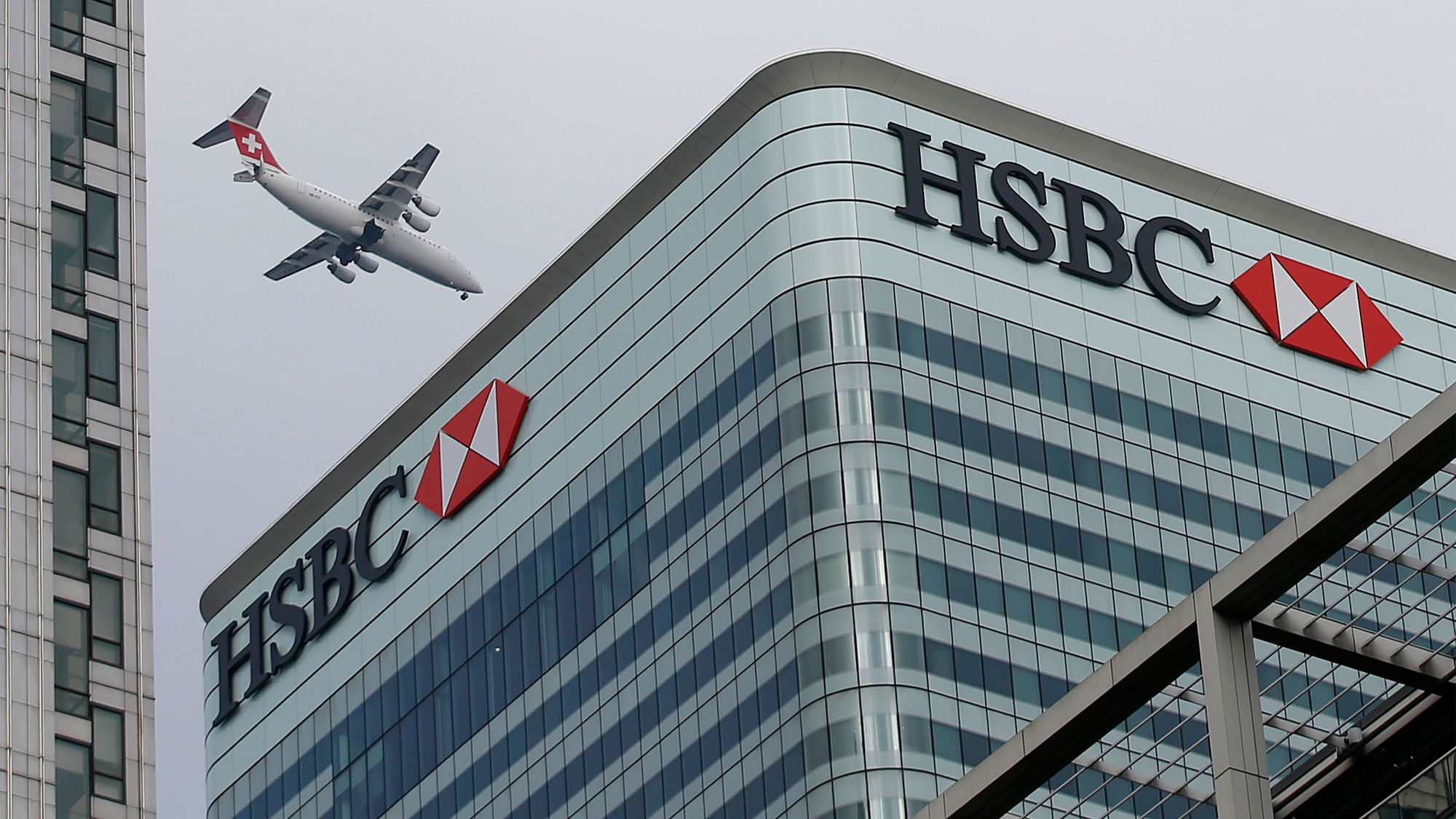 

A Swiss International aircraft flies past the HSBC headquarters building in the Canary Wharf financial district in east London. (Photo: Reuters)