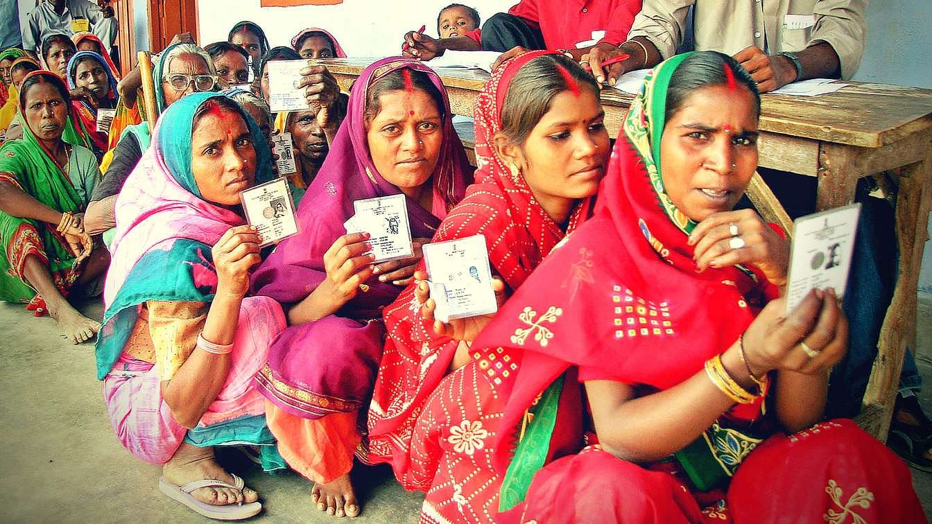 Bihar Assembly Elections 2020: Women hold up their voter ids for a photographer as they wait outside a polling booth in rural Bihar. Image used for representation.
