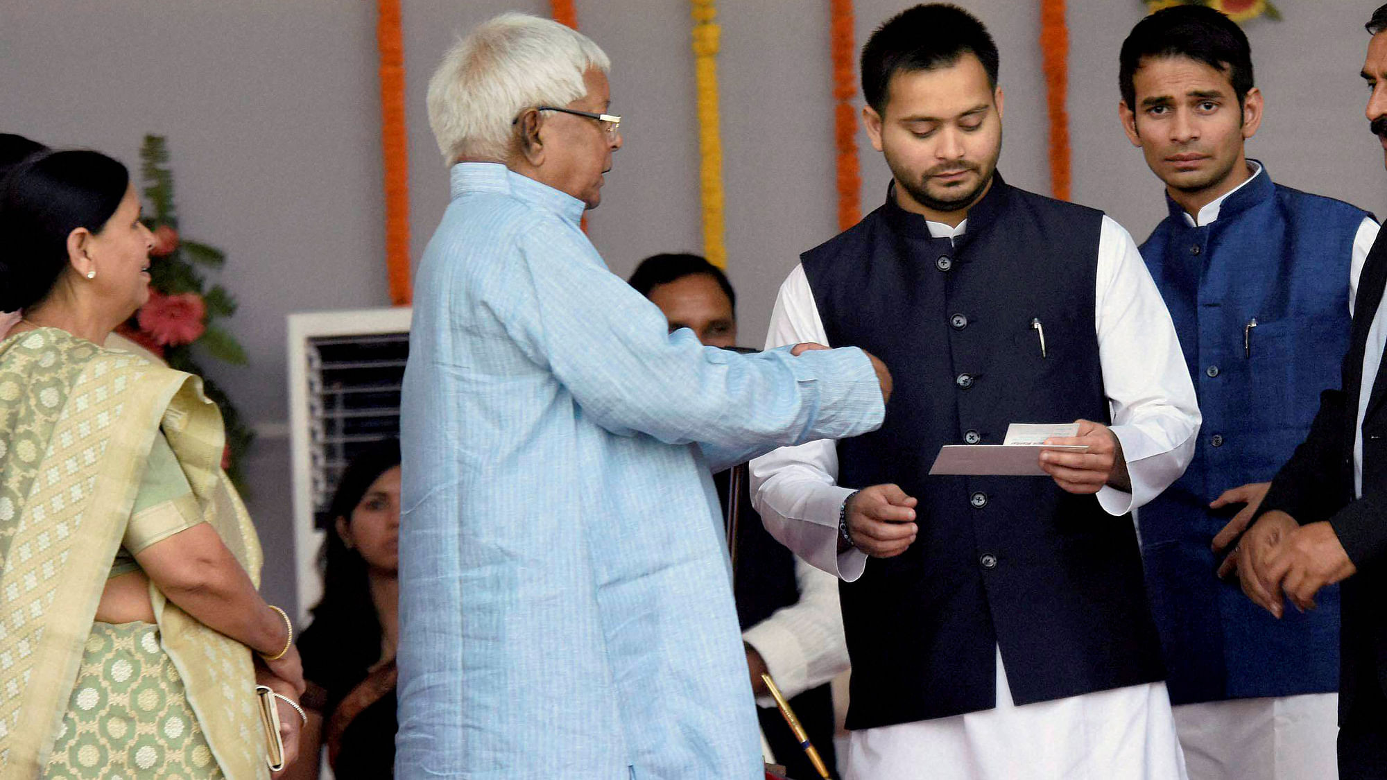 RJD chief Lalu Prasad with his wife Rabri Devi and his sons during the swearing-in ceremony at Gandhi Maidan in Patna on Friday. (Photo: PTI)