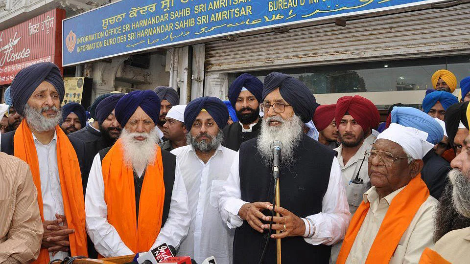 A file picture of Punjab Chief Minister Parkash Singh Badal (speaking into a public address system) and Deputy Chief Minister Sukhbir Singh Badal (to Badal senior’s right). (Photo courtesy: Shiromani Akali Dal’s <a href="https://www.facebook.com/AkaliDalBadal/photos/pb.268373753220345.-2207520000.1448356320./326160747441645/?type=3&theater">Facebook</a> page)