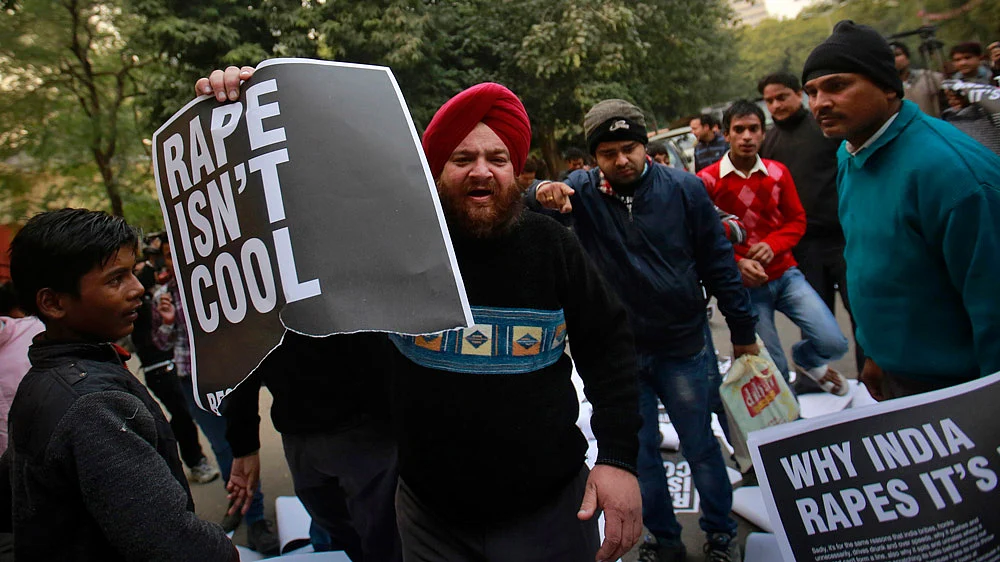 A demonstrator holds a torn poster during a protest in New Delhi, December 29, 2012. (Photo: Reuters)