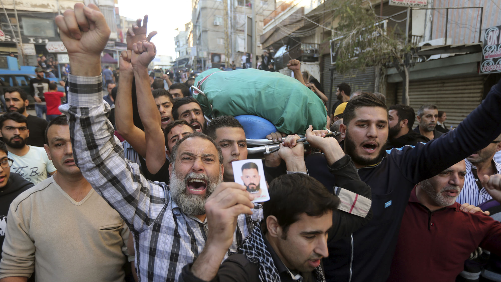 Relatives and comrades carry the body of Samer Abdel-Karim Houhou, a member of Amal movement party, who was killed in the two explosions. November 13, 2015. REUTERS/Hasan Shaaban