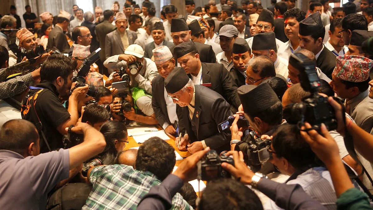 Communist Party of Nepal (Unified Marxist-Leninist) leader KP Oli (Centre) signs the constitution document. (Photo: AP)