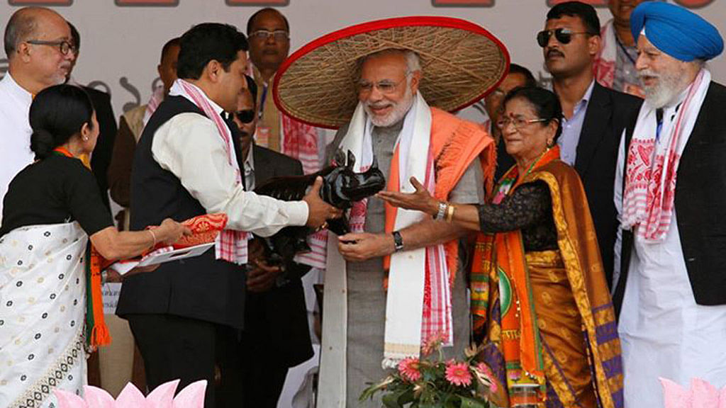 Narendra Modi wearing a “Japi” (a traditional hat of Assam) receives a wooden Rhino by his supporters during a rally ahead of the 2014 general elections, at Guwahati 2014. (Photo: Reuters)