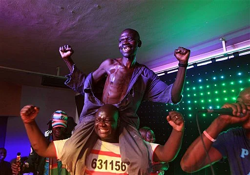Mison Sere reacts, top, after winning the 2015 edition of the Mr Ugly competition, in Harare. (Photo: AP)