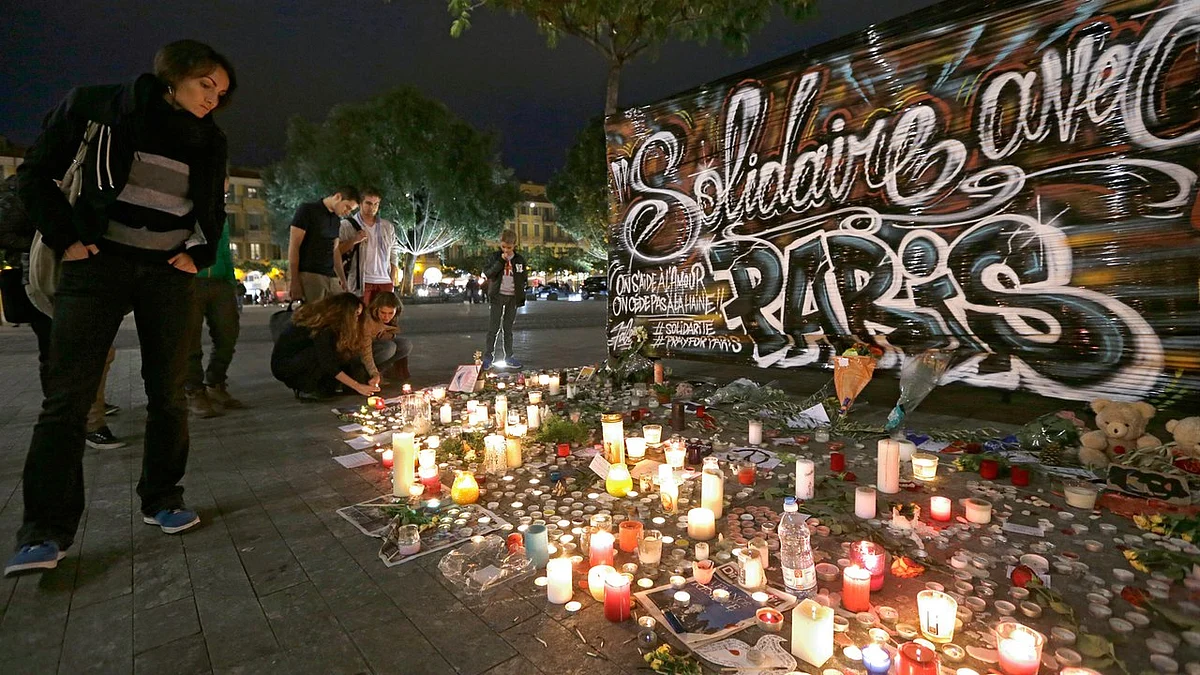 People pay tribute to the victims of the terror attacks in Paris by a poster which reads “Solidarity with Paris” in Nice, southeastern France, November 16, 2015. (Photo: AP)