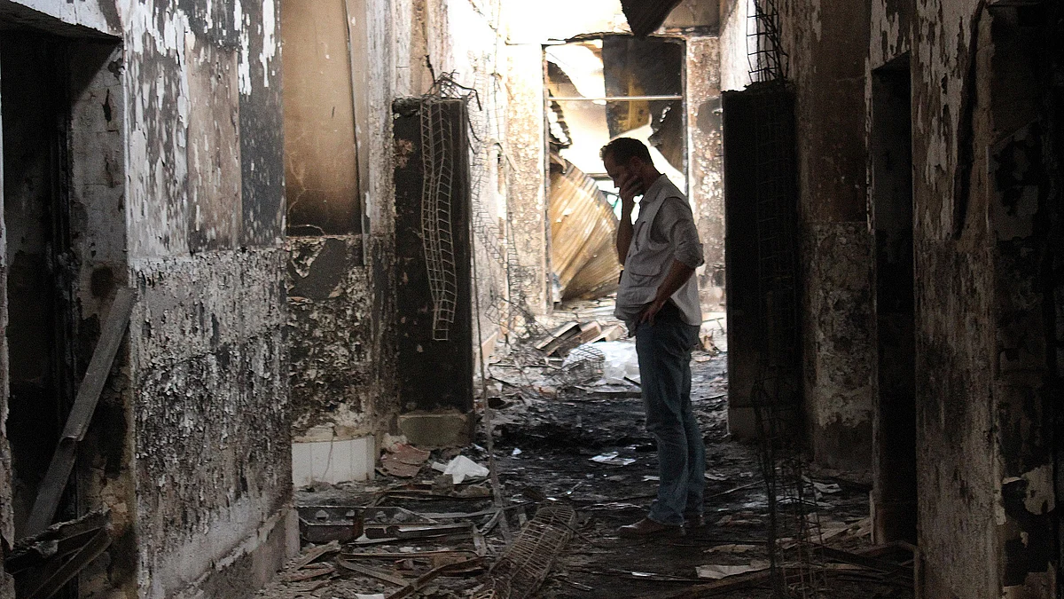 In this Friday, Oct. 16, 2015, file photo, an employee of Doctors Without Borders walks inside the charred remains of their hospital after it was hit by a U.S. airstrike in Kunduz, Afghanistan. (Photo: AP)