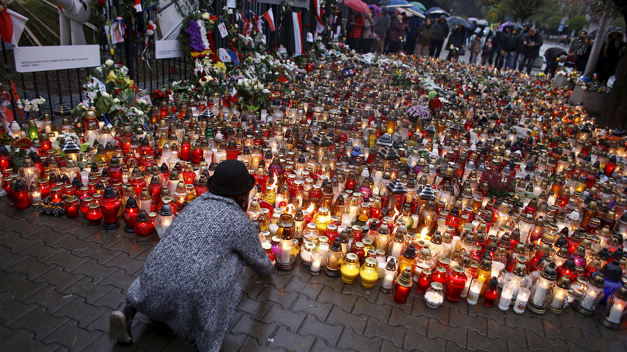 A girl lays a candle in front of the French embassy in
Poland. (Photo: Reuters) &nbsp; &nbsp; &nbsp;
