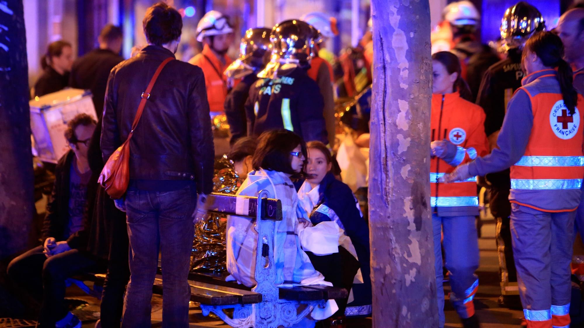 People rest on a bench after being evacuated from the Bataclan theatre in Paris following a shooting. (Photo: AP)