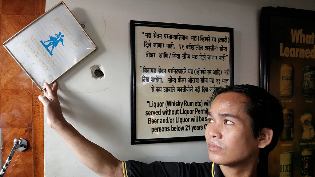 A staff member displays a bullet hole in the wall of Leopold Cafe, which was one of the targets of the 26/11 attacks in Mumbai. (Photo: Reuters)