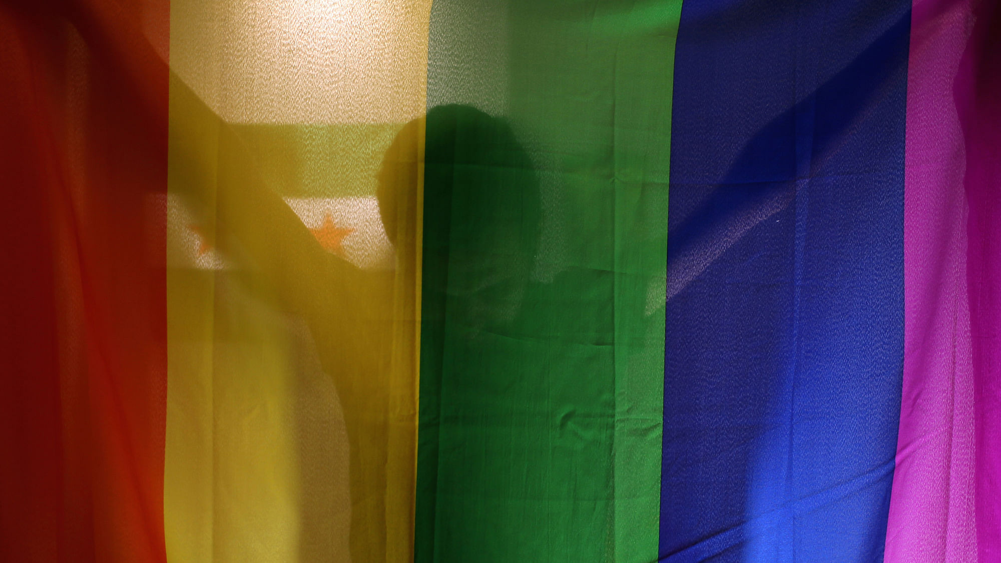 Daniel Halaby, a gay Syrian who fled from the Islamic State group, poses with the rainbow flag symbolic of LGBT rights in his apartment in southern Turkey. (Photo: AP)