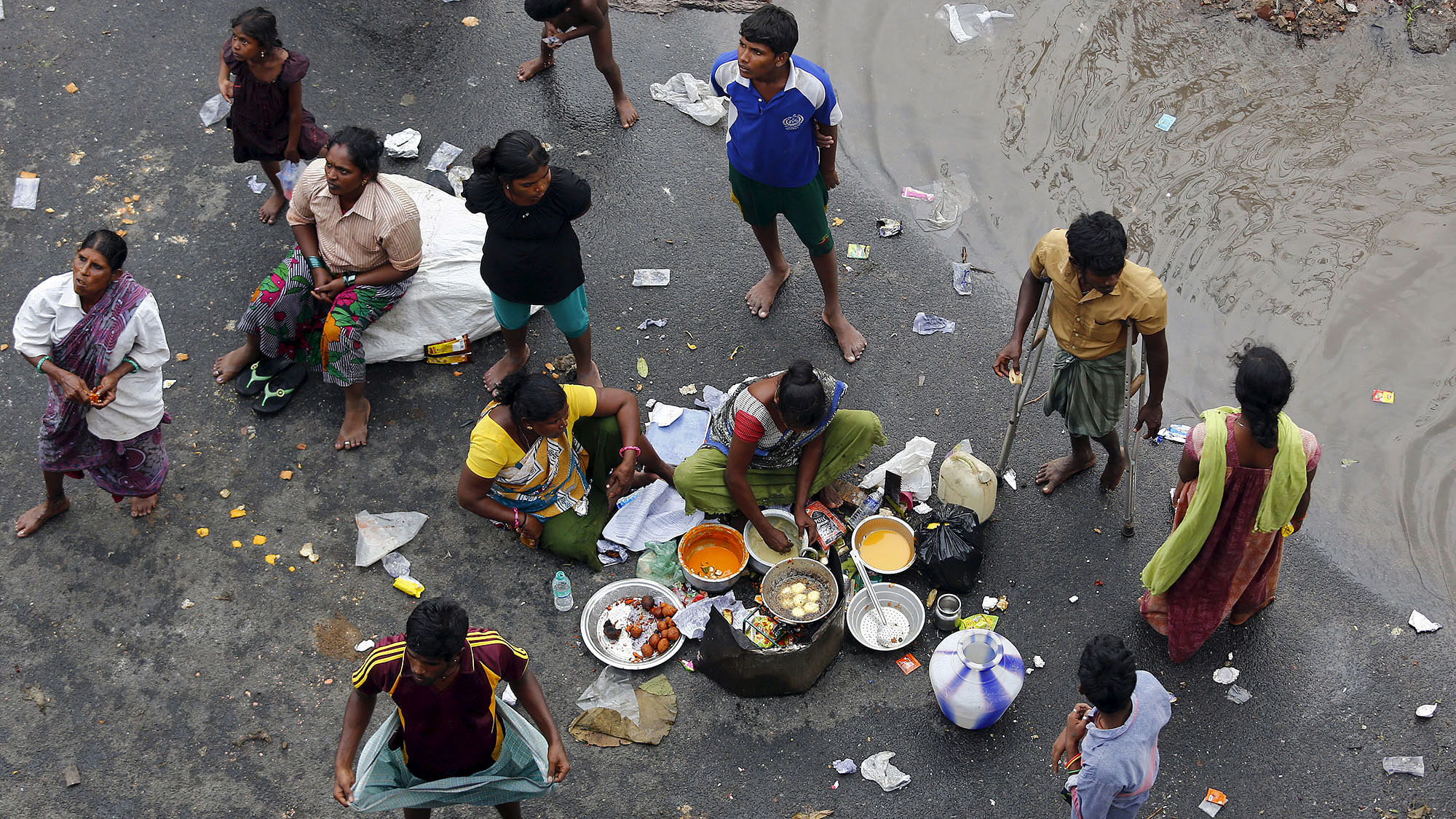 Displaced residents cook their meal on a flooded roadside in Chennai. (Photo: Reuters)