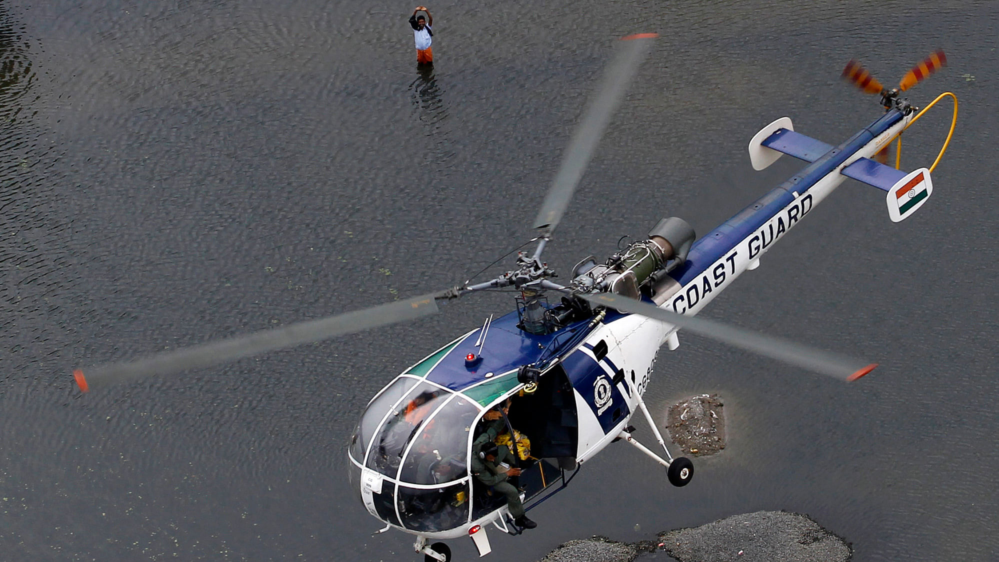 A flood-affected man waves to a coastguard
chopper in Chennai. (Photo: AP)