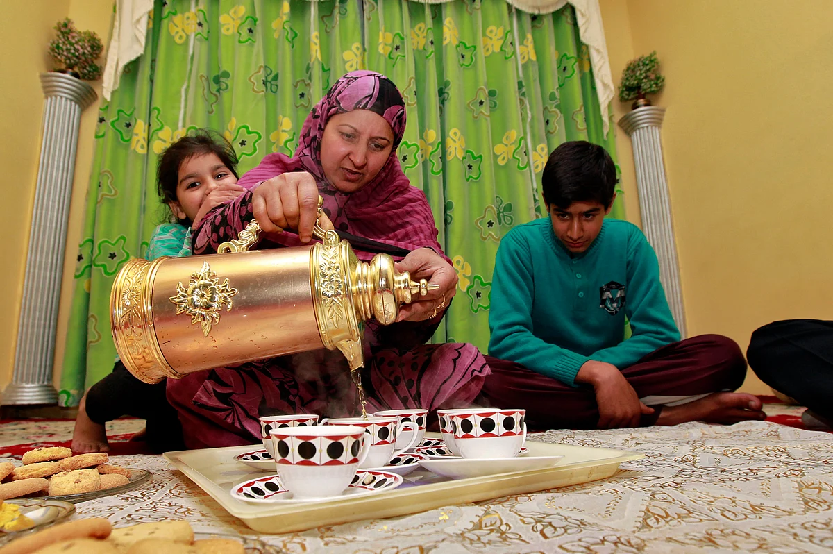 A Kashmiri Muslim woman pours saffron Kahwa into cups before serving it to guests in Srinagar. (Photo: Reuters)
