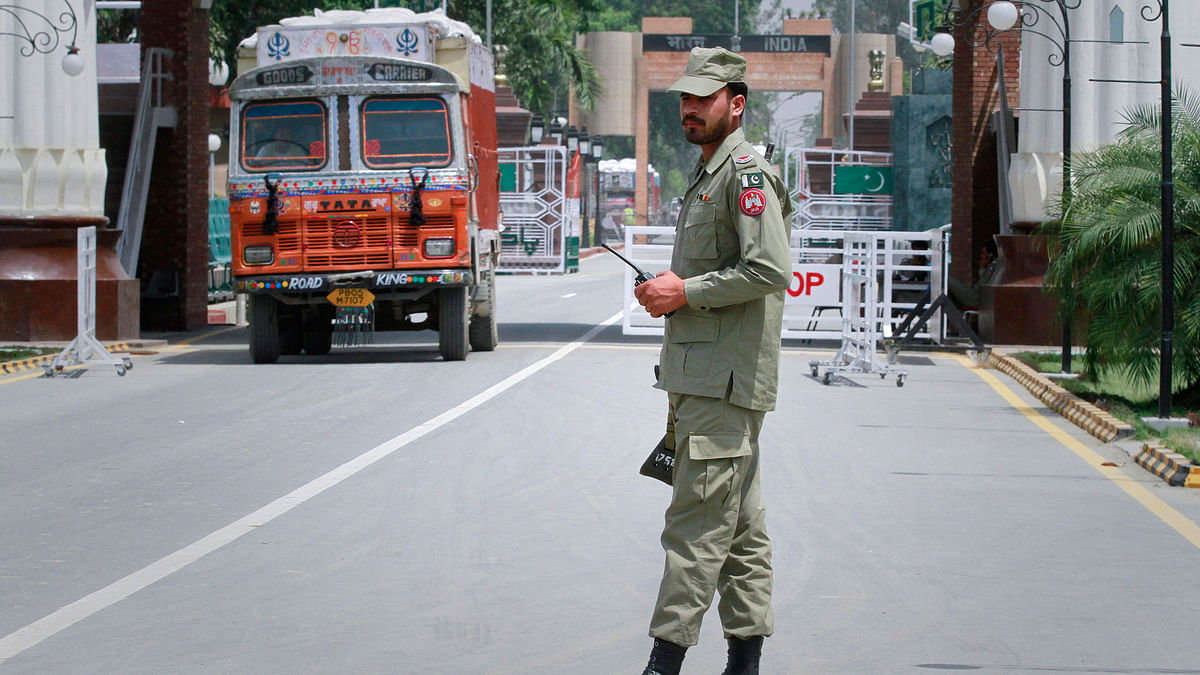 A paramilitary soldier stands guard as a truck carrying wheat crosses into Pakistan from India, at the Wagah border. (File photo: Reuters)