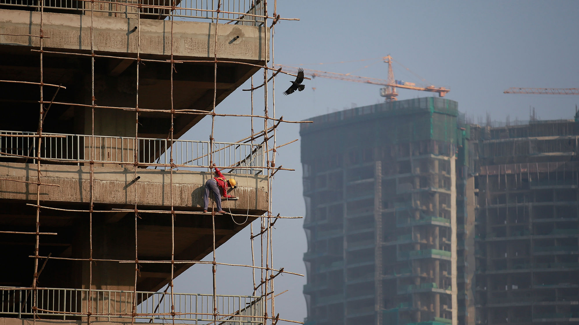 A labourer stands on wooden scaffolding as he works at the construction site of a commercial building in Mumbai’s central financial district January 16, 2015. (Photo: Reuters)