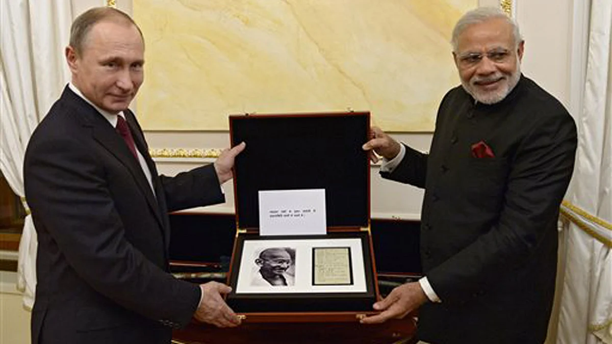 Russian President Vladimir Putin presents Indian Prime Minister Narendra Modi a page from the diary of Mahatma Gandhi on Thursday. (Photo: AP)