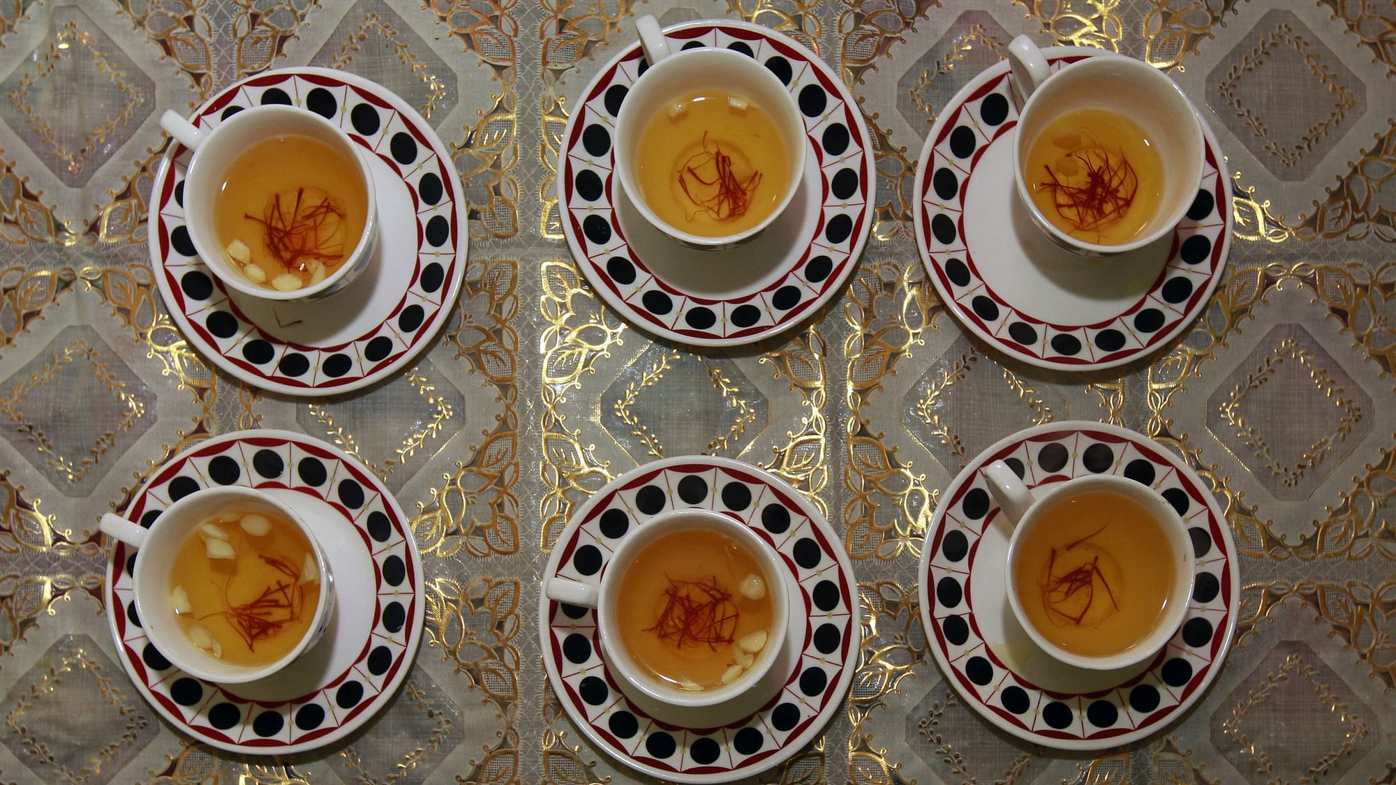 Dried saffron and almonds seen in cups filled with <i>kahwa</i>, a traditional Kashmiri sweet tea, in Srinagar. (Photo: Reuters)