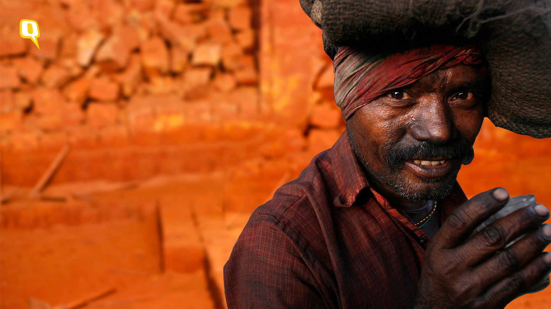 A labourer poses at a roadside coal store on a highway on the outskirts of Kolkata. (Photo: Reuters)