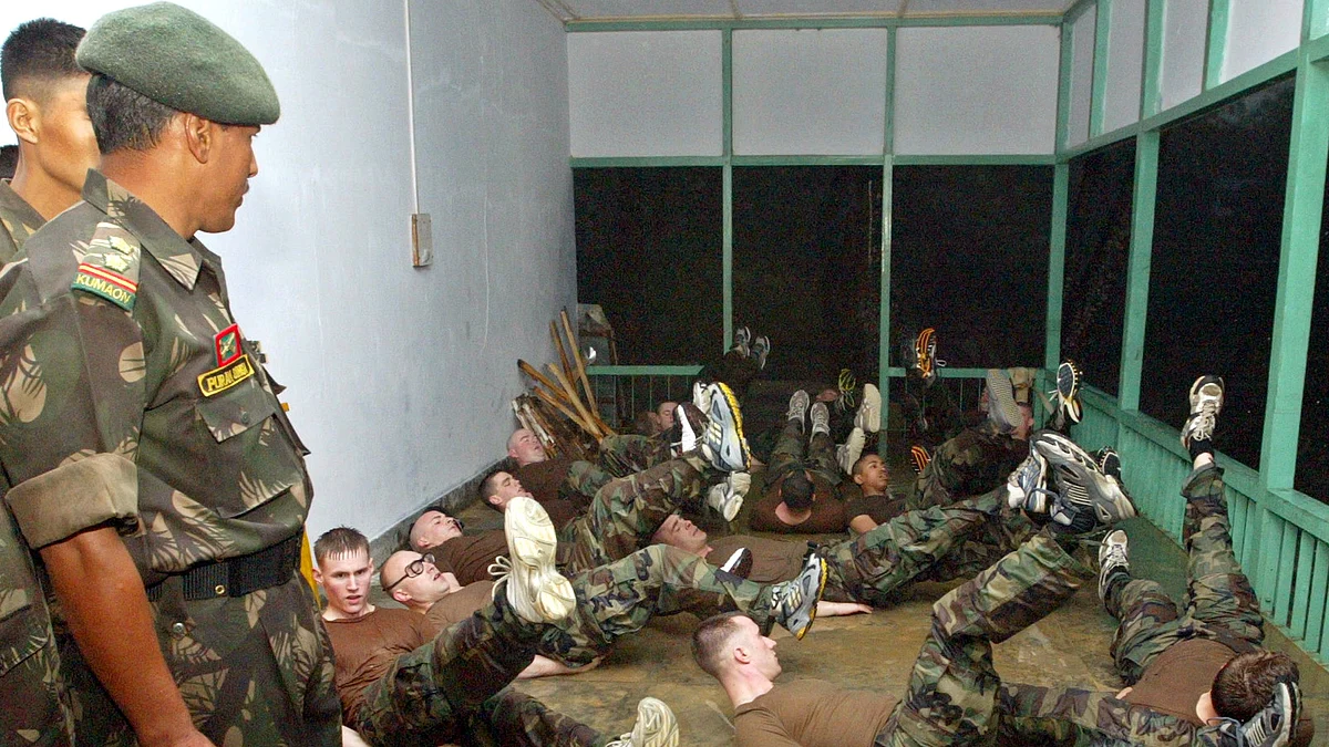 US soldiers work out during a joint Indo-US military exercise as an Indian army officer (L) looks on in Kumbhirgram in Mizoram, April 6, 2004. (Photo: Reuters)