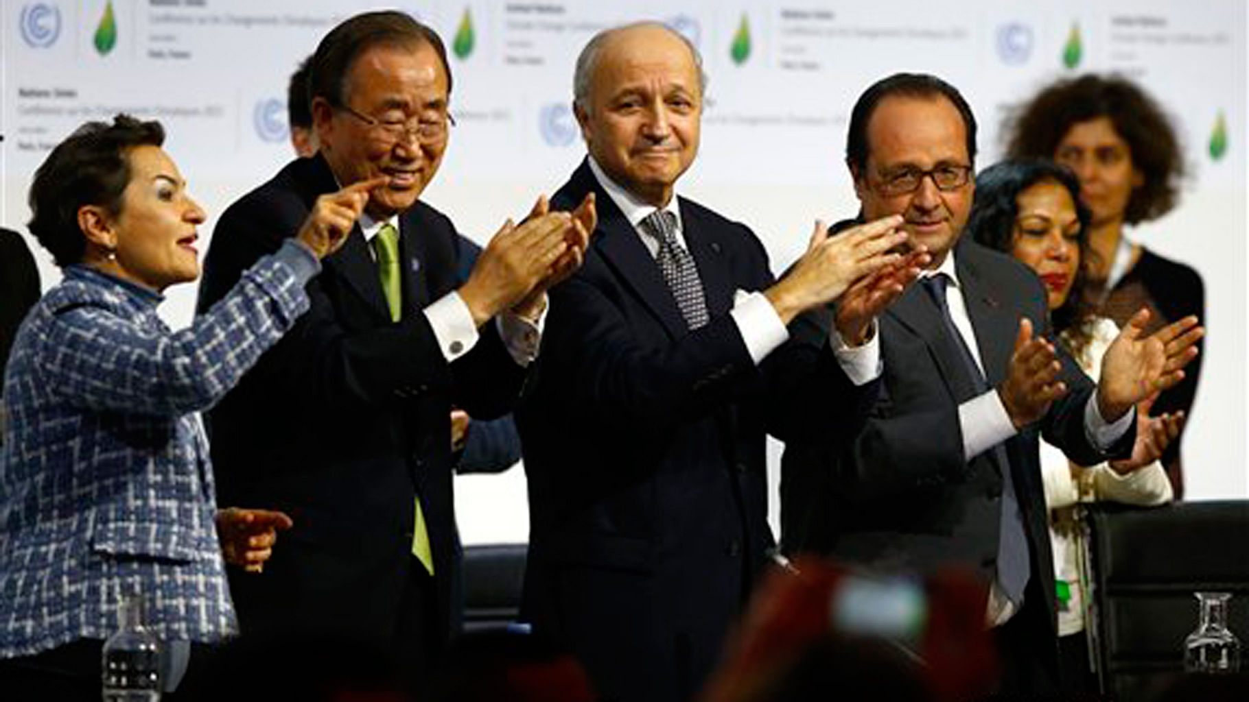From the right French President Francois Hollande, French Foreign Minister and President of the COP21 Laurent Fabius, UN Secretary General Ban ki-Moon and UN Climate Chief Christiana Figueres applaud after the final conference at the COP21 in Paris on Saturday. (Photo: AP)