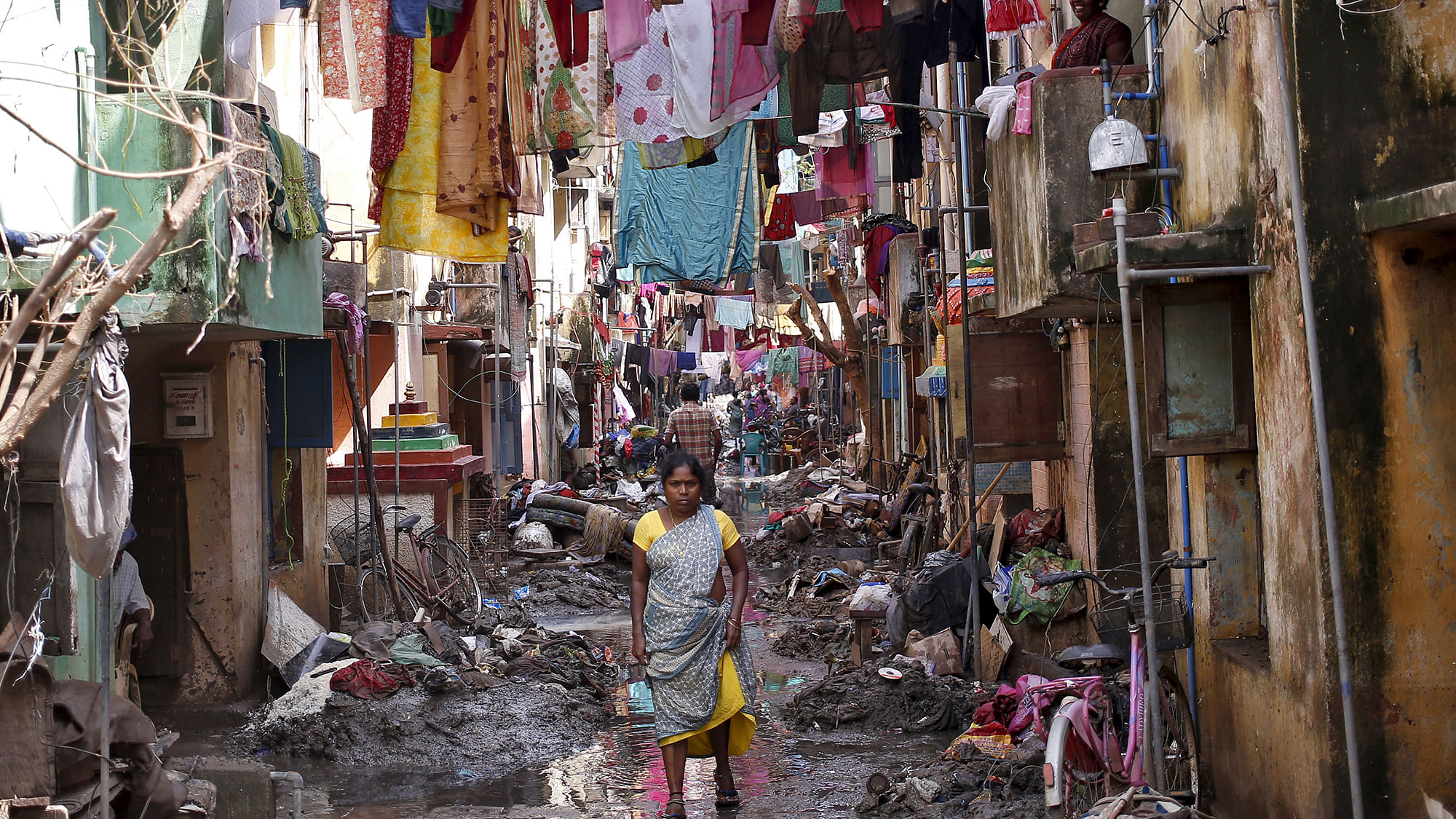 A woman walks in an alley filled with mud and debris in Chennai. (Photo: Reuters)