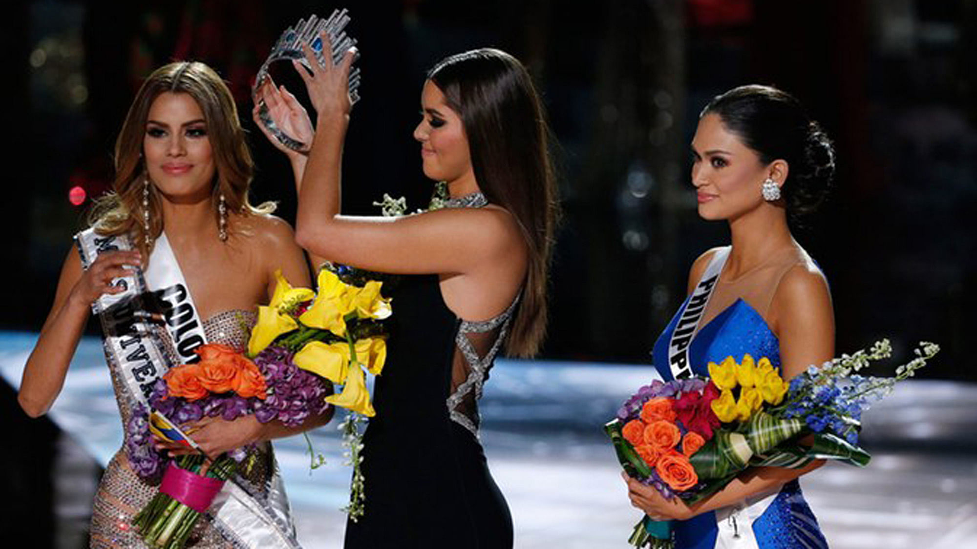 Former Miss Universe Paulina Vega, center, takes the crown off Miss Colombia Ariadna Gutierrez, left, before crowning  Miss Philippines Pia Alonzo Wurtzbach. (Photo: AP)