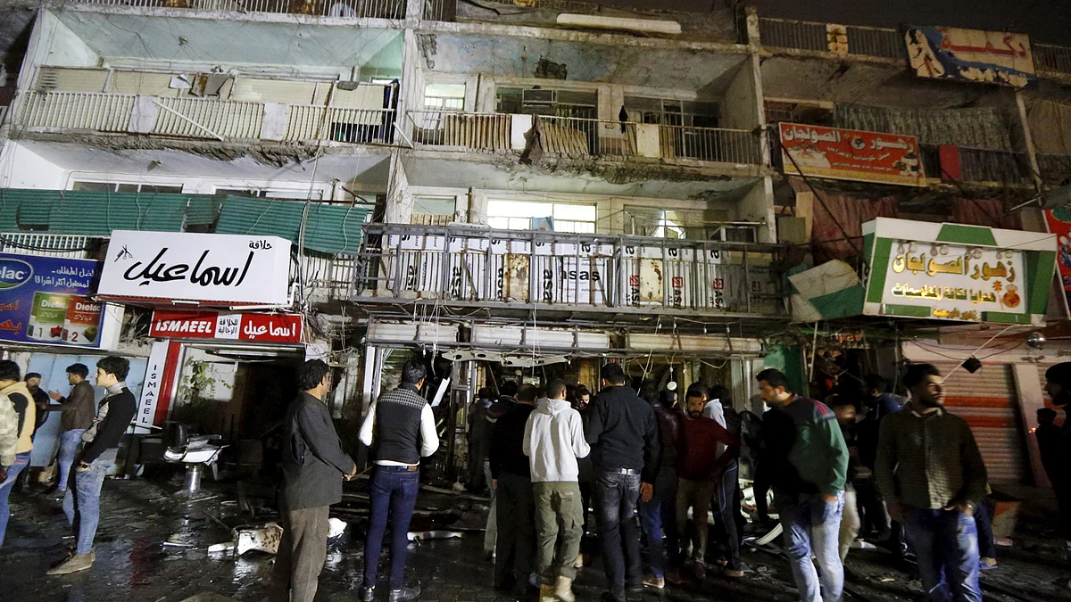 File photo: People gather at the site of a car bomb in New Baghdad on 11 January 2016. (Photo: Reuters)