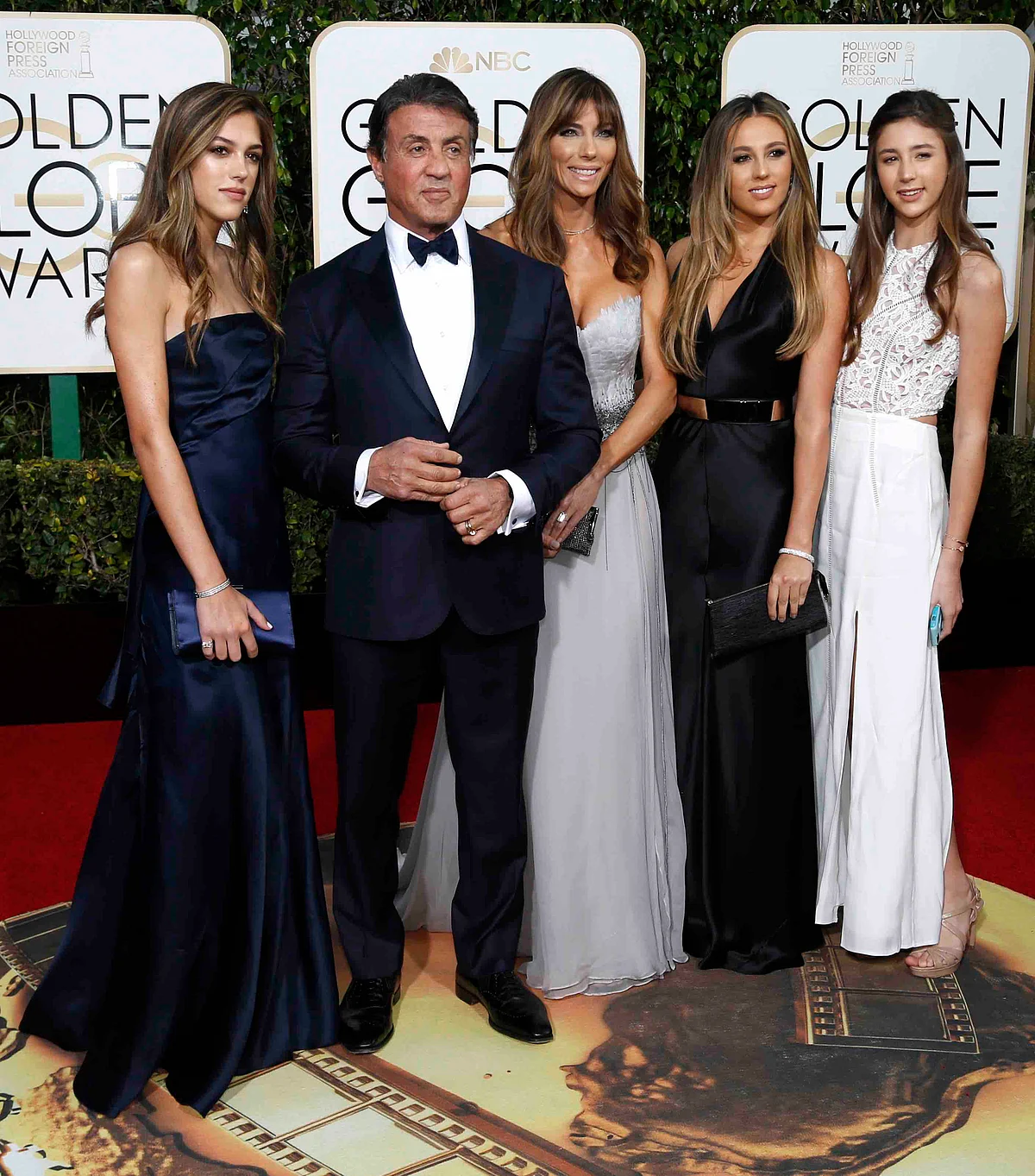 Sylvester Stallone poses with his wife and daughter in a deep blue suit (Photo: Reuters)