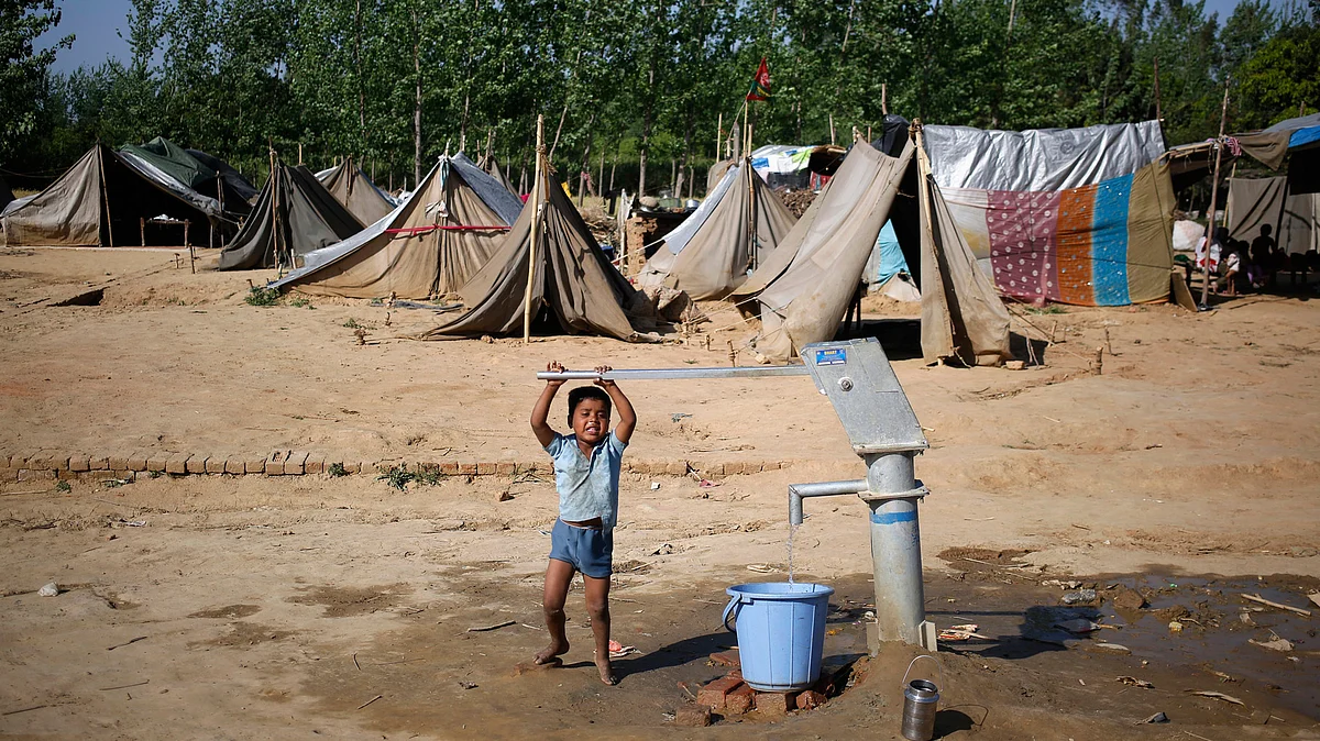 A child fills a water bucket using a hand pump at a relief camp in the village of Kutba, Muzaffarnagar, affected by 2013 riots in Uttar Pradesh, April 9, 2014. (Photo: Reuters)