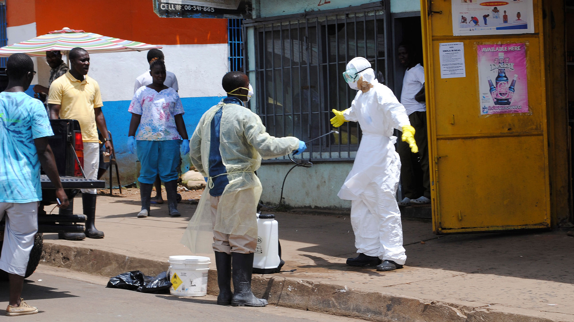 Member of a burial team sprays a colleague with chlorine disinfectant in Monrovia, capital of Liberia on October 20, 2014. (Photo: Reuters)