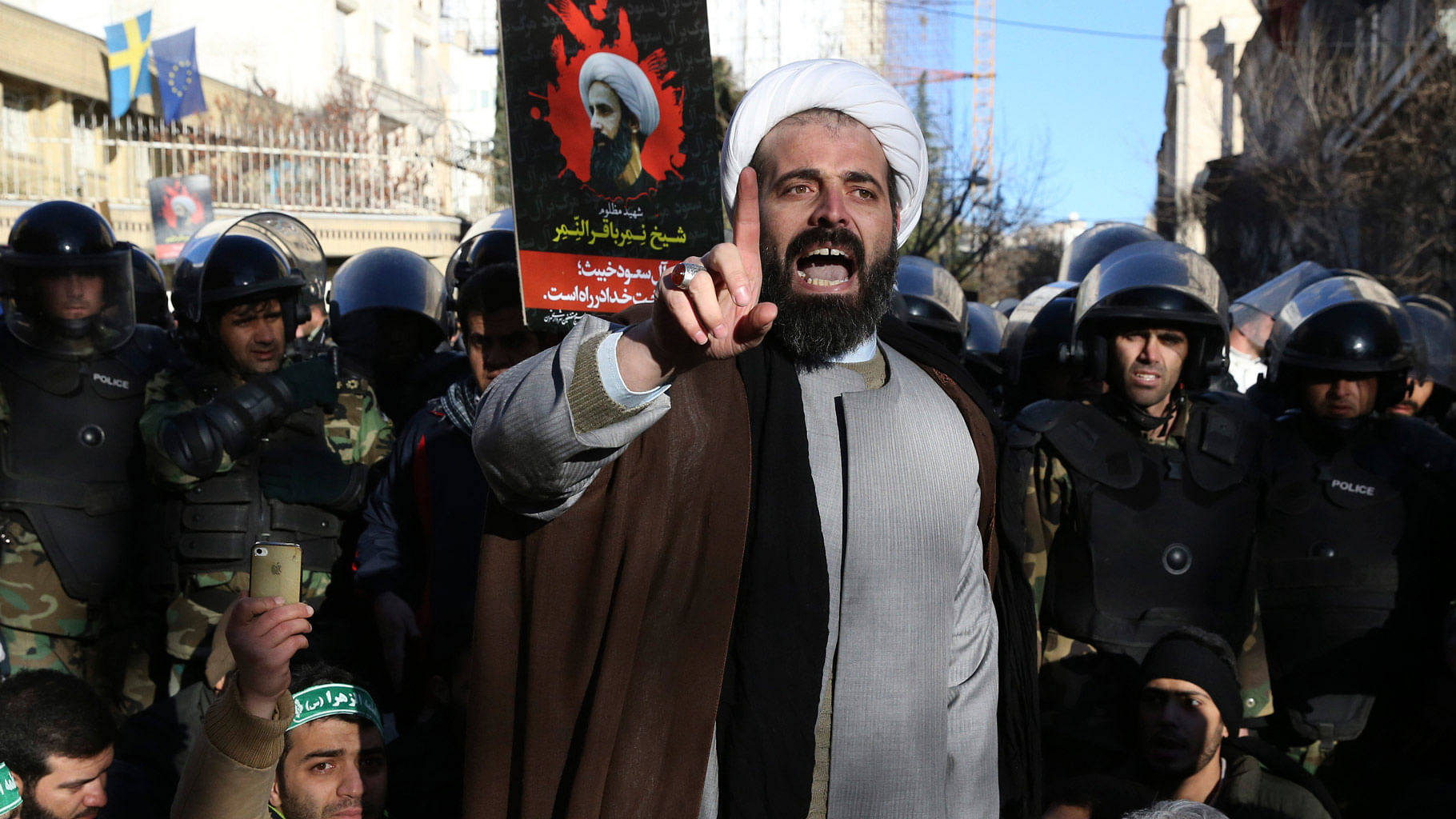 

A Muslim cleric addresses a crowd during a demonstration to protest the execution of al-Nimr, shown in the poster in background, in front of the Saudi embassy in Tehran. (Photo: AP)
