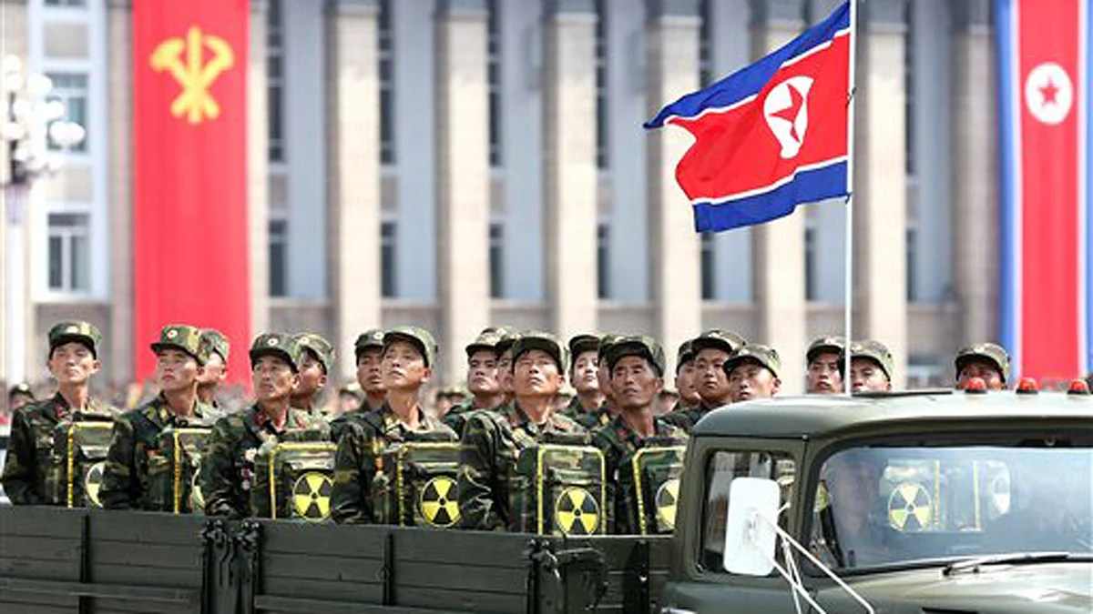 North Korean soldiers carry packs marked with the nuclear symbol. (Photo: AP)