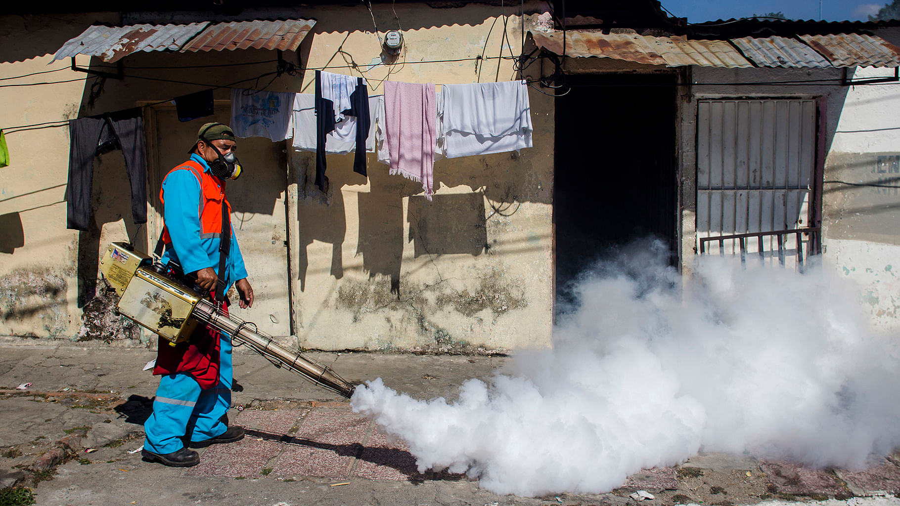 A city worker fumigates to combat the Aedes Aegypti mosquitoes that transmit the Zika virus, at the San Judas Community in San Salvador, El Salvador, on Tuesday, 26 January 2016.  (Photo: AP)