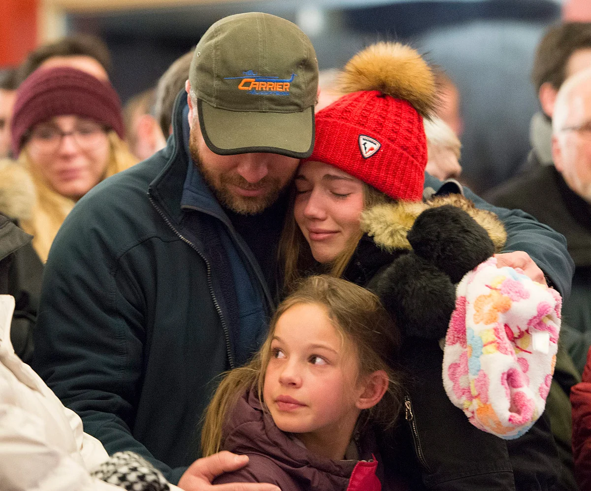 A man who lost his father in the attacks, grieves with his two daughters. (Photo: AP)