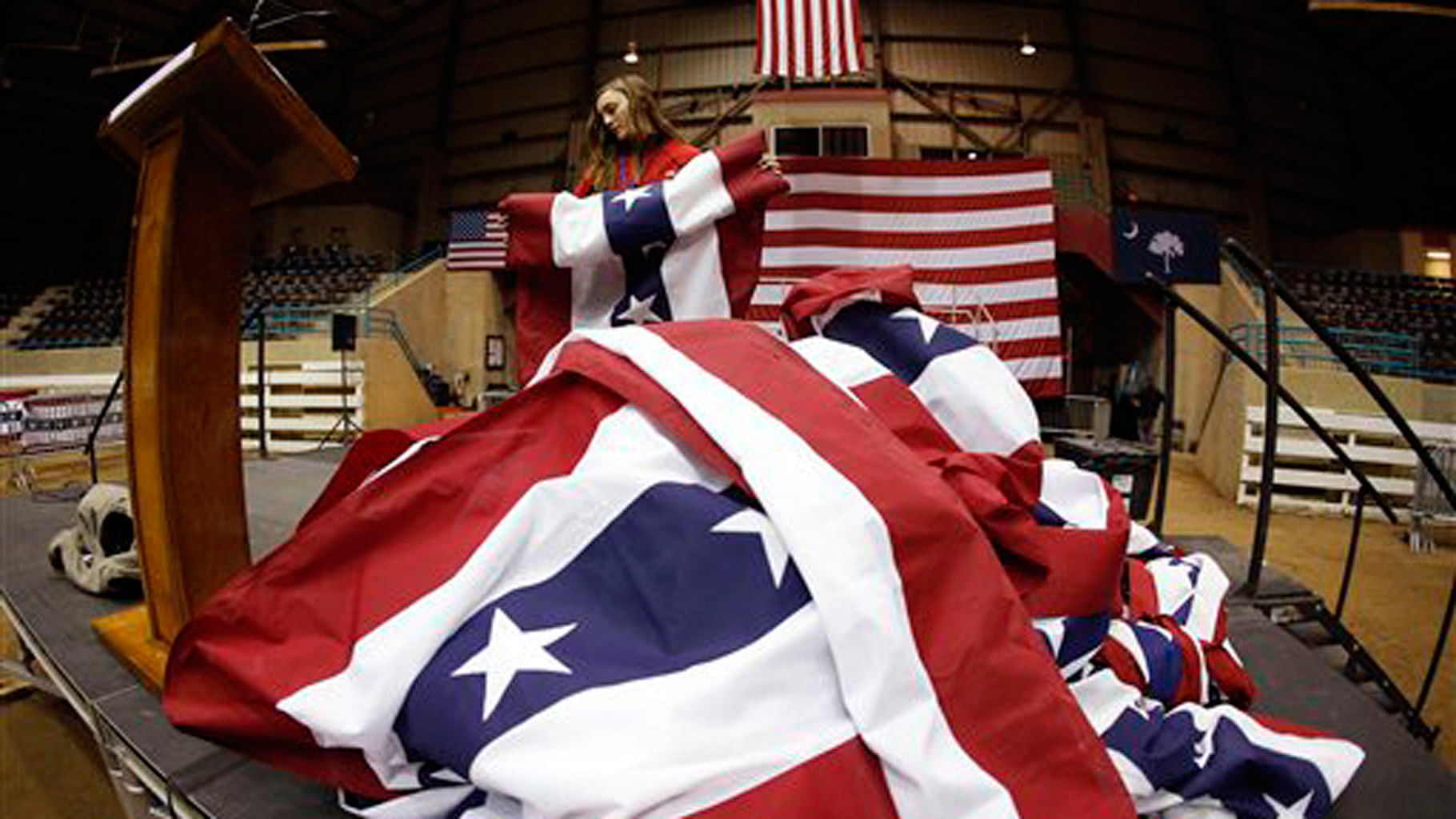 A volunteer rolls up bunting at a rally. (Photo: AP)