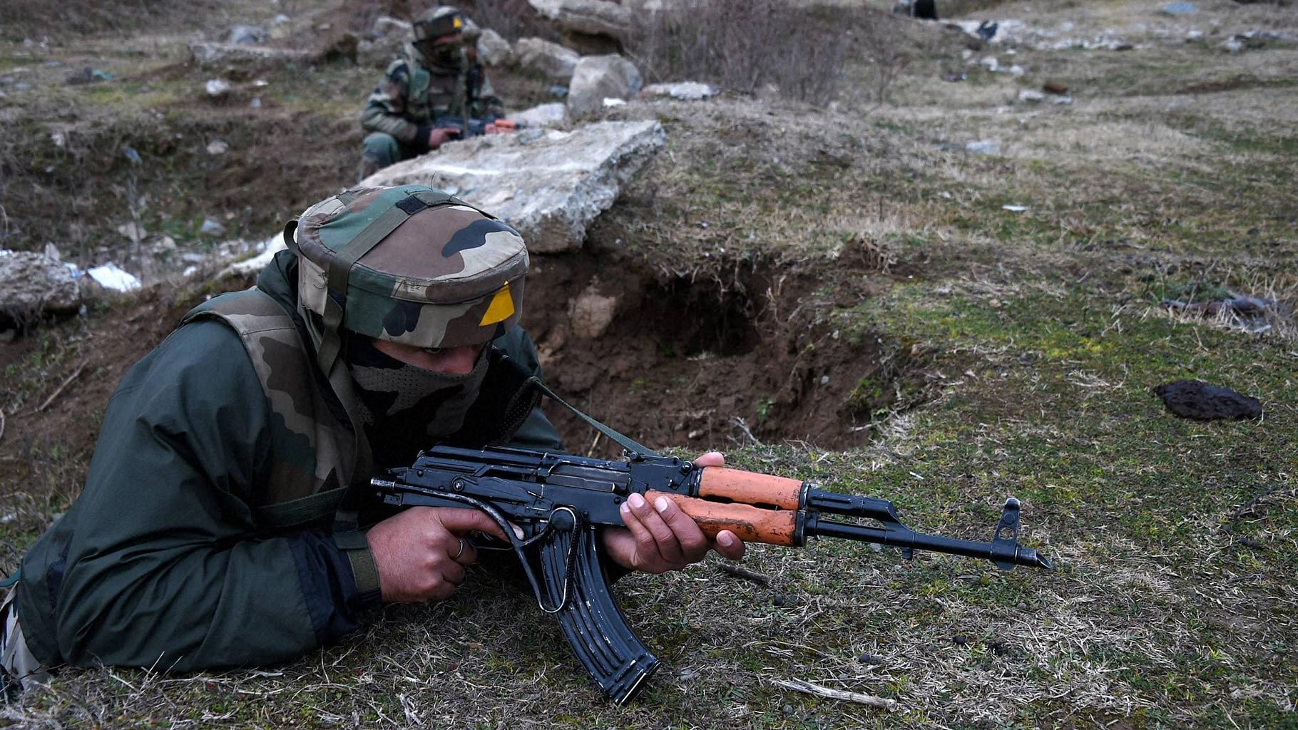 A security forces personnel takes position outside the JKEDI building where militants have reportedly taken refuge after launching an attack on a CRPF convoy at Sampora Pampore, near Srinagar on Saturday. (Photo: PTI)