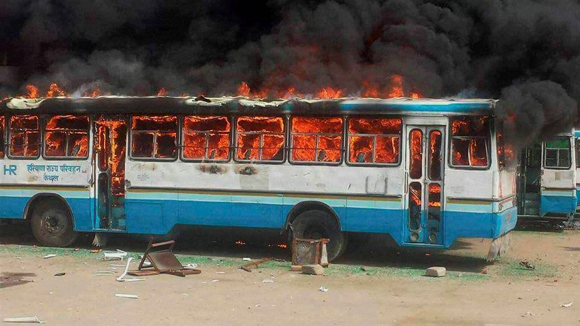 Jat community members torch a Haryana Roadways bus during their agitation for reservation. (Photo: PTI)   