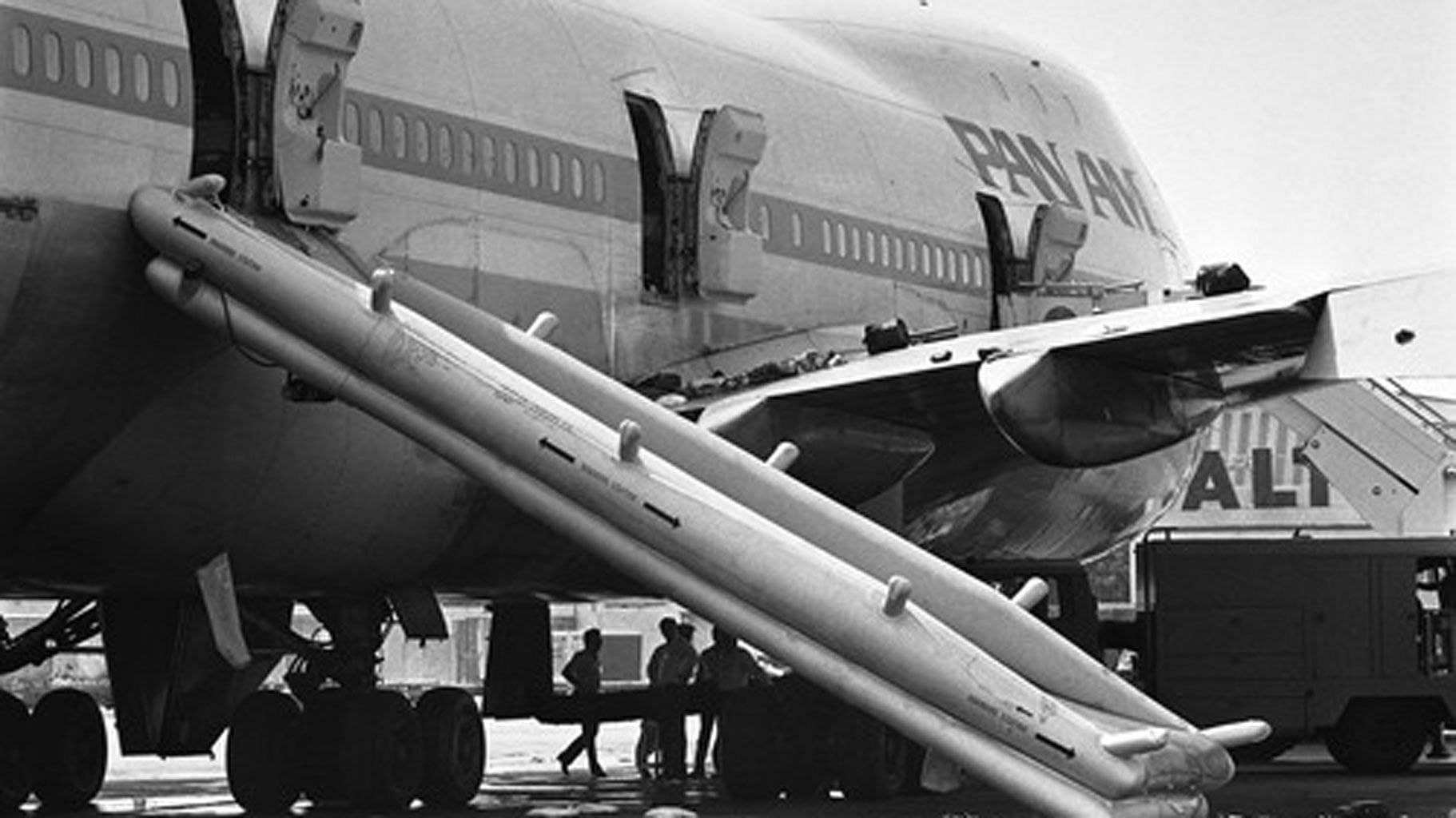 Pakistani policemen investigate the Pan Am jetliner under the emergency chute in Karachi, Pakistan on Saturday morning, 6 September 1986. (Photo: AP)