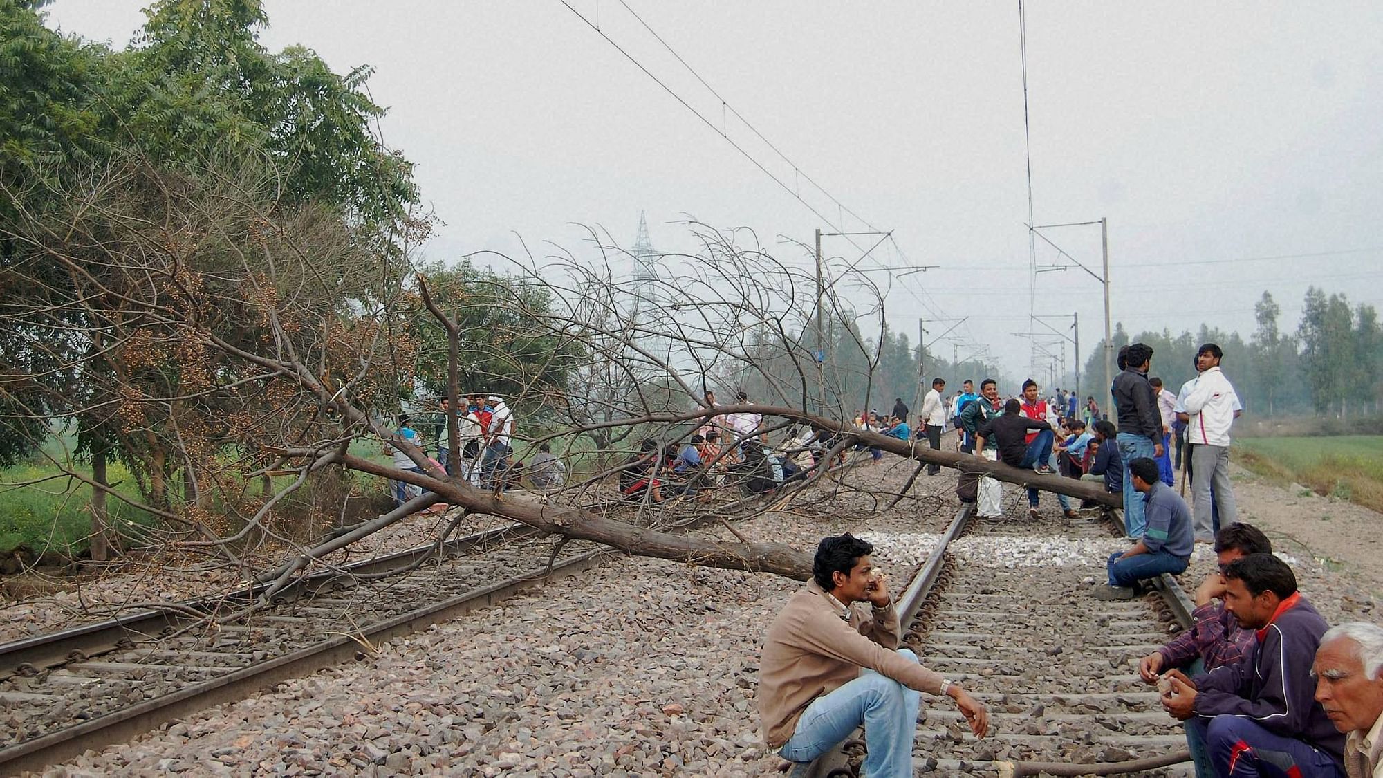  Jat community members block the railway tracks during their agitation for reservation in Sonipat on Friday. (Photo: PTI)