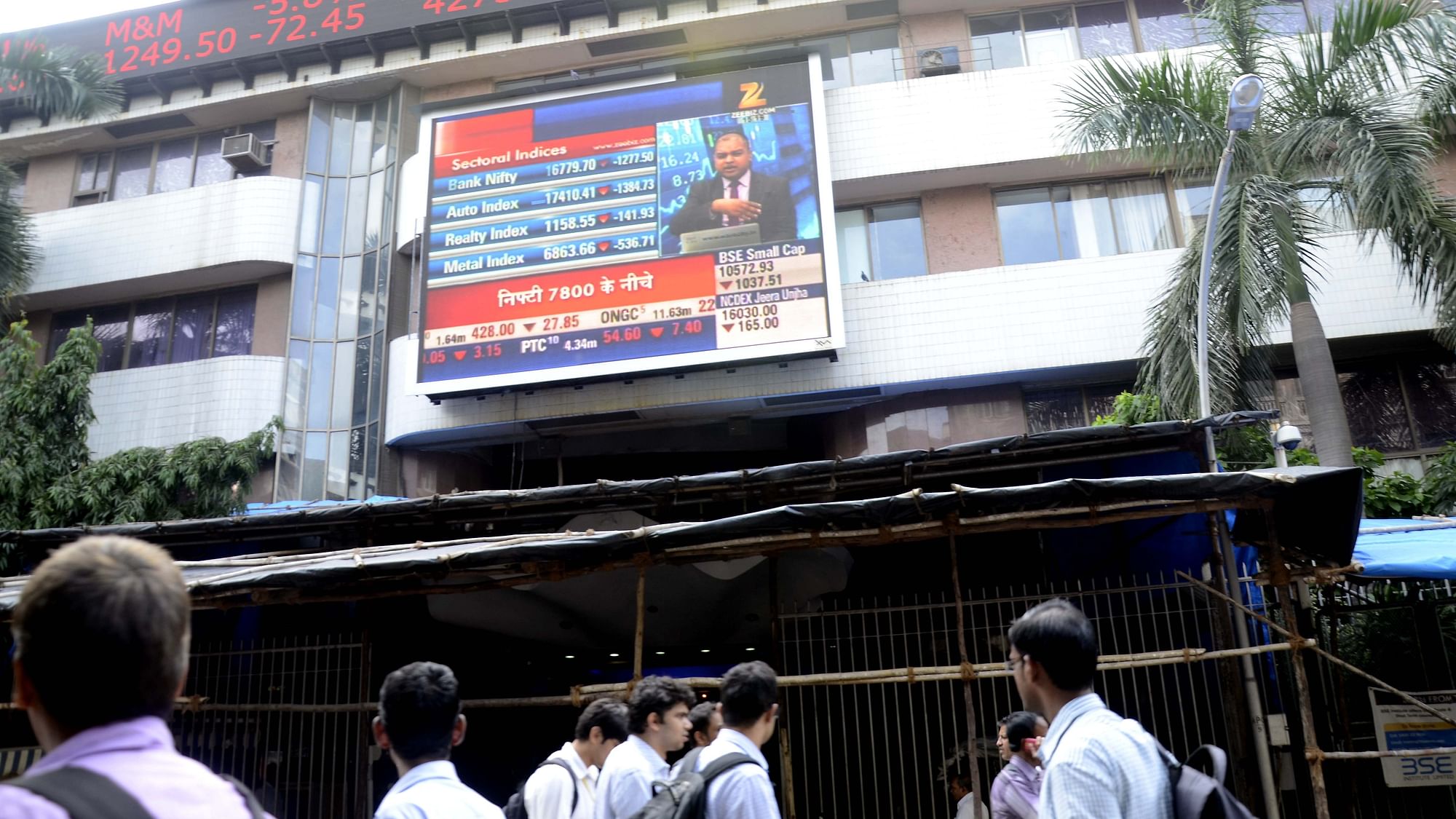 People outside the Bombay Stock Exchange react as weak global cues and a steep fall in Shanghai stocks, along with concerns over the Indian government’s stand on minimum alternate tax (MAT), shaved 1039.34 points, or nearly 3.80 percent, off a key equity index of the Bombay Stock Exchange (BSE) in Mumbai, on 24 August 2015. (Photo: IANS)